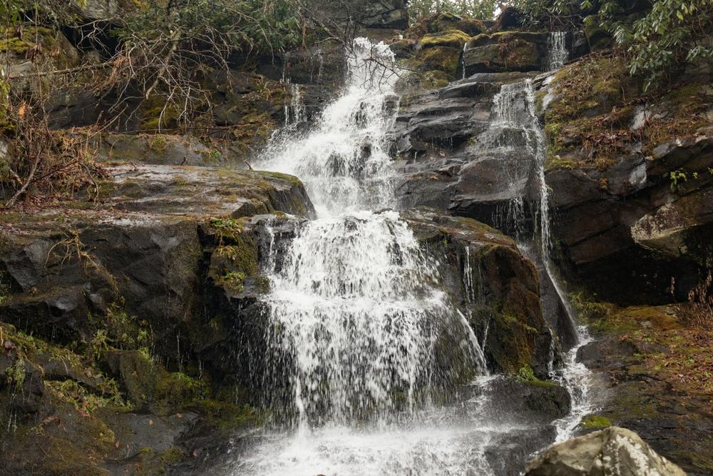 Walk along scenic forest paths to admire a tall, narrow cascade.