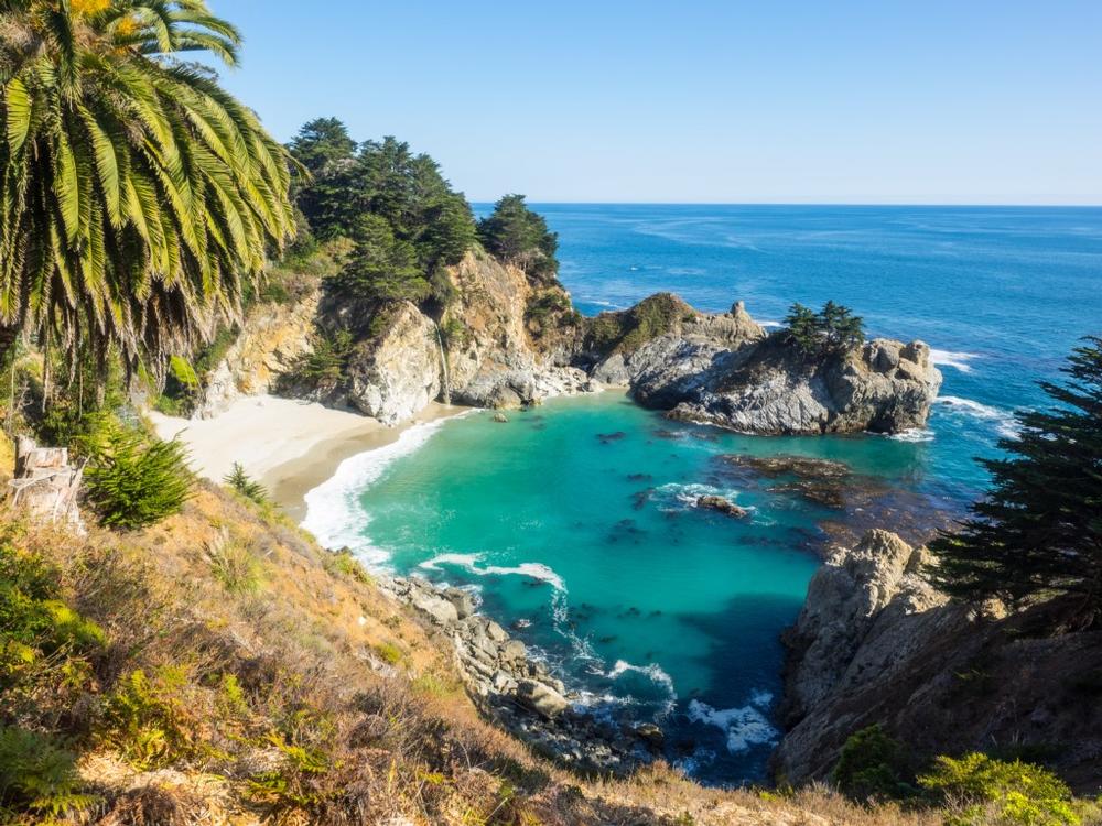 Photograph purple sand and explore sea arches during a scenic trip.